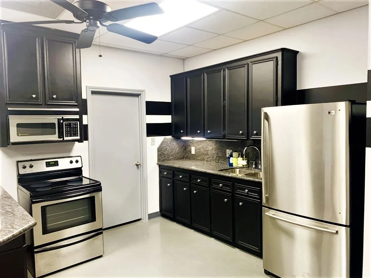 Kitchen with cabinets painted black and fresh white walls